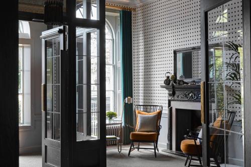 a living room with a chair and a fireplace at Kimpton Charlotte Square by IHG in Edinburgh