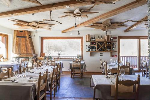 a dining room with tables and chairs and ceiling fans at Hotel Edelweiss in Limone Piemonte