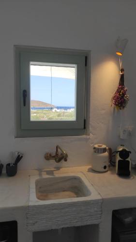 a kitchen sink with a window above it at Salty Yard Holiday Home in Serifos Chora