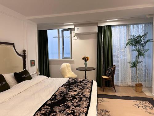 una camera d'albergo con letto, tavolo e finestre di Shanghai Hills & Panorama River Suite Close to Metro Line 4 a Shanghai