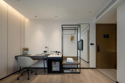 a room with a desk and a chair and a mirror at Atour Hotel Hangzhou Hubin Pinghai Road in Hangzhou