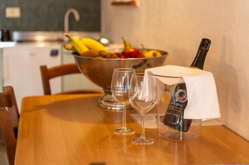 a table with two wine glasses and a bowl of fruit at Residence Nube D'Argento in Sestriere