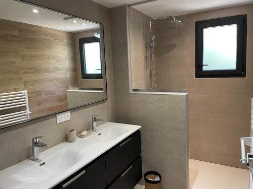 un bagno con due lavandini e un grande specchio di Maison Rez-de-jardin 80 m de la plage a Serra di Ferro