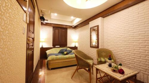 a room with a bed and a table and chairs at 井原商事ハートランド井門 in Tokyo