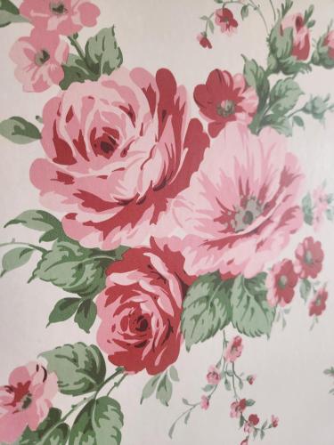 a painting of pink flowers on a wall at Hem till Gården boutique hotel in Västerås