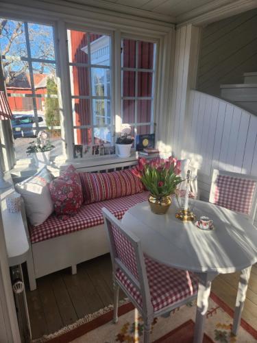 a porch with a bench and a table and a couch at Hem till Gården boutique hotel in Västerås