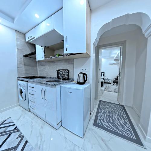 a kitchen with white cabinets and a washer and dryer at PRETTY HOUSE in Pamukkale