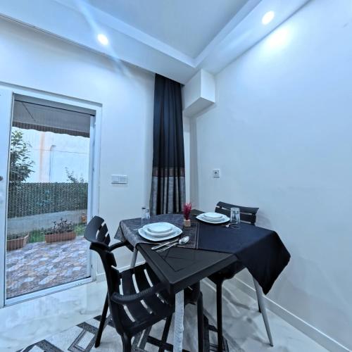 a dining room with a black table and chairs at PRETTY HOUSE in Pamukkale