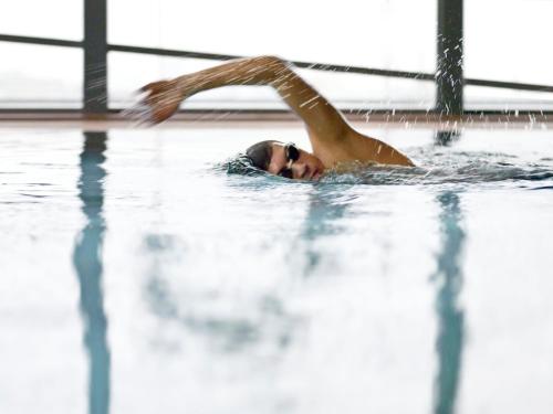 a woman swimming in a swimming pool at Grand Hyatt Berlin in Berlin