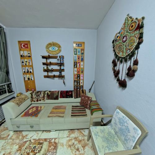 a living room with a white couch and chairs at PRETTY HOUSE in Pamukkale