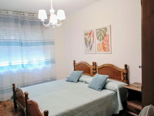 ein Schlafzimmer mit einem Bett mit blauen Kissen in der Unterkunft Espectaculares vistas a la Ría de Aldán in Bueu