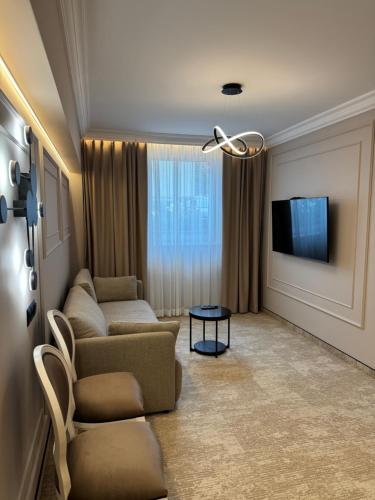 a living room with a couch and a tv at Moris Beach Hotel in Gdańsk