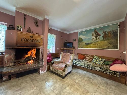 a living room with a fireplace and a couch at Etno Rekreacia Tabatadze, With in Door & Out door pool 