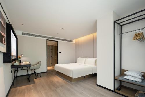 a bedroom with a white bed and a desk at Atour Hotel Hangzhou Hubin Pinghai Road in Hangzhou