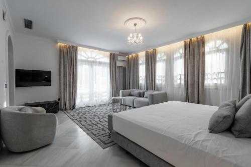 a bedroom with a large bed and a living room at Palacio Suites Marbella in Marbella