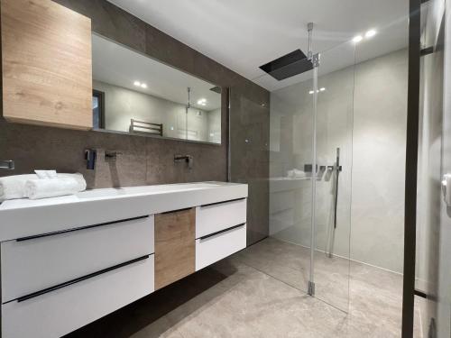 une salle de bain avec un lavabo blanc et une douche dans l'établissement Grand-Duc Résidence avec piscine - 2 pièces, à Mandelieu-la-Napoule