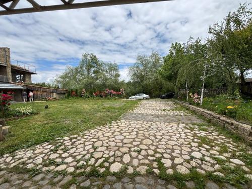 a cobblestone road with a car parked in a yard at Etno Rekreacia Tabatadze, With in Door & Out door pool 