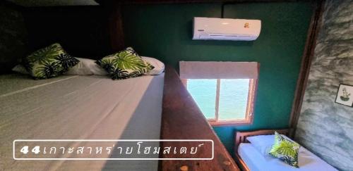 two bunk beds in a room with a window at 44Kohsaraihomestay 44เกาะสาหร่ายโฮมสเตย์ in Satun