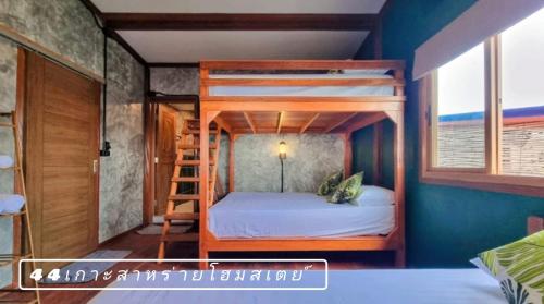 a bedroom with two bunk beds with a ladder at 44Kohsaraihomestay 44เกาะสาหร่ายโฮมสเตย์ in Satun