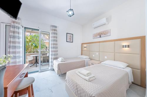 カボスにあるEli Guesthouseのベッド2台、デスク、キッチンが備わるホテルルームです。