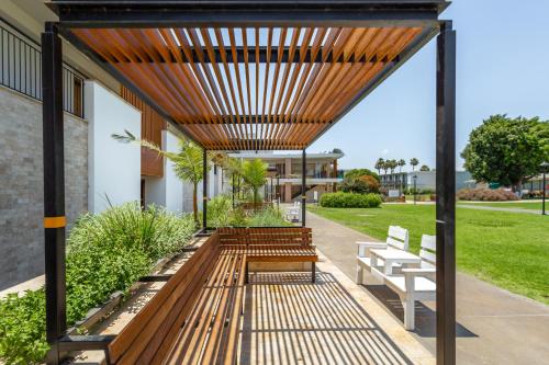 a pergola over a porch of a house with benches at Nof Ginosar Kibbutz Hotel in Kibbutz Ginnosar