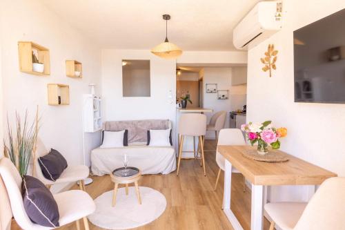 un salon avec un canapé et une table dans l'établissement Appartement Cosy avec Vue Mer au 4e, à Valras-Plage