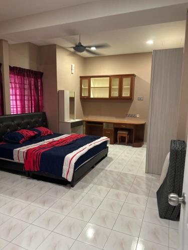 a bedroom with a bed and a desk in it at MM Homestay 80 in Kamunting