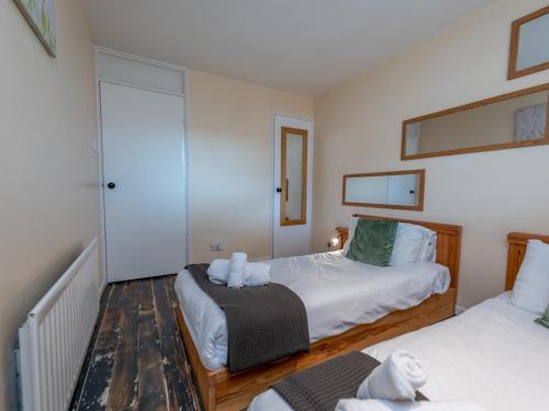 a small bedroom with two beds and a mirror at Pass the Keys Cosy Spacious Garden House in Bridgnorth