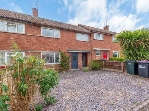 a brick house with a gravel driveway in front of it at Pass the Keys Cosy Spacious Garden House in Bridgnorth