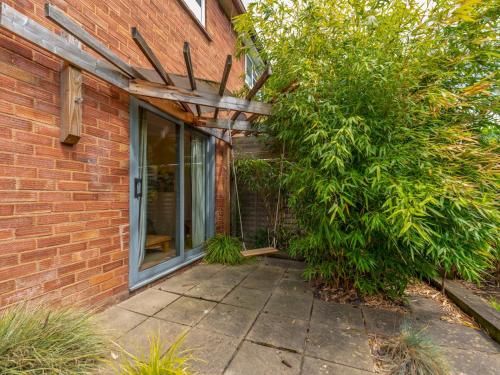 a brick house with a window and a tree at Pass the Keys Cosy Spacious Garden House in Bridgnorth
