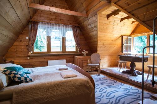1 dormitorio en una cabaña de madera con cama y piano en Osada Oleńka Witów en Witów