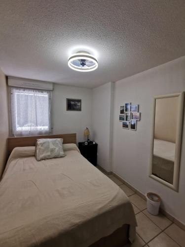 une chambre avec un lit et un miroir dans l'établissement 2-room apartment near St-Tropez, à La Garde-Freinet