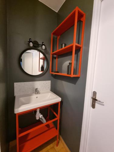 une salle de bain avec un lavabo et un miroir dans l'établissement Maison proche de la plage, à Saint-Pierre-dʼOléron