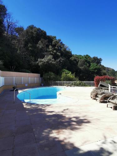 une piscine avec des chaises, une clôture et des arbres dans l'établissement 2-room apartment near St-Tropez, à La Garde-Freinet