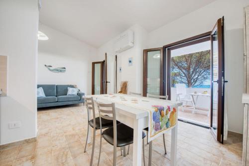 a dining room with a white table and chairs at Villa Nella in Cala Liberotto