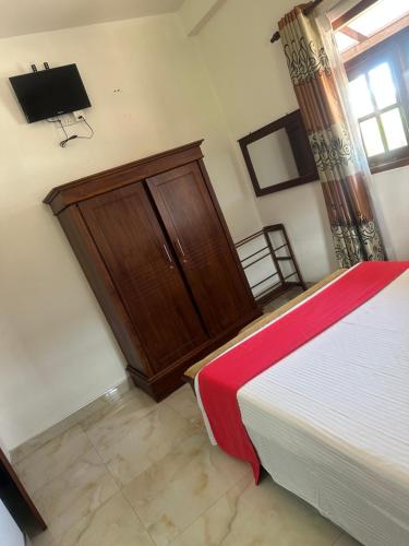 a bedroom with a bed and a wooden door at Ryan Residence & Restaurant in Negombo