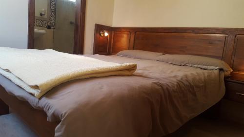 プエルト・デル・カルメンにあるSunset Balconyのベッドルーム1室(木製ヘッドボード付きのベッド1台付)