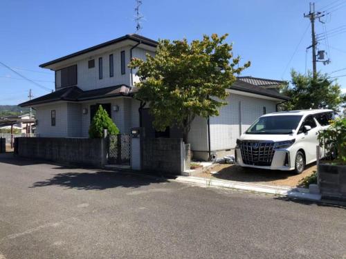 a white car parked in front of a house at 中山民宿奈良若草山下的乡间别墅 in Nara