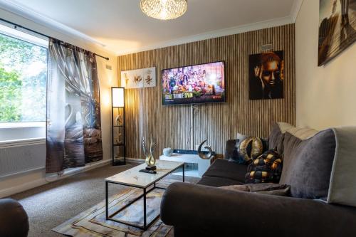 a living room with a couch and a tv at Sweet Dream Lodge in Manchester