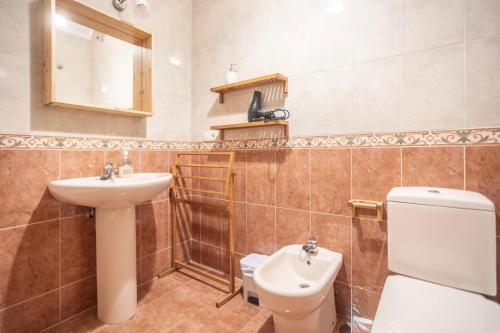 a bathroom with a toilet and a sink at Apartamento Ría San Esteban in San Esteban de Pravia