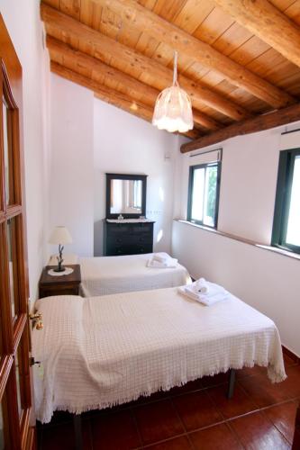 two beds in a room with two windows at LA SERRERÍA in Galaroza