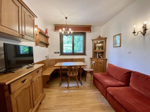 Cozy flat in amazing central location في كورتينا دامبيتزو: غرفة معيشة مع أريكة حمراء وطاولة