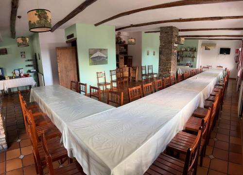 a long row of tables and chairs in a room at Hotel rural casa Ferreiro in Seoane
