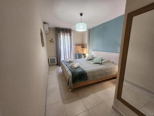 une chambre avec un lit et un miroir dans l'établissement Sunflower Cavalaire - Wifi - Clim - Parking, à Cavalaire-sur-Mer