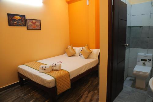 a small room with a bed and a toilet at Tharavaadu by Le Apex in Puducherry