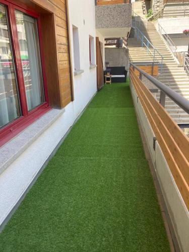 a walkway with green grass on the side of a building at Appartement at the heart of Saas Fee in Saas-Fee