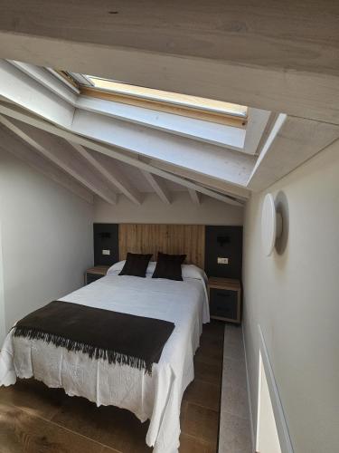 a bedroom with a large bed with a skylight at La Barata Apartamentos in Colombres