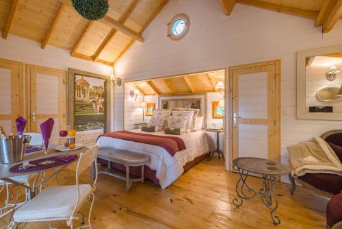 a bedroom with a bed and a table and chairs at Domaine de Pech et Lafon Cabanes avec SPA privatif dans les arbres in Clairac