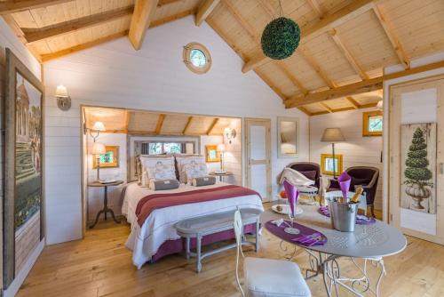 a bedroom with a bed and a table with chairs at Domaine de Pech et Lafon Cabanes avec SPA privatif dans les arbres in Clairac
