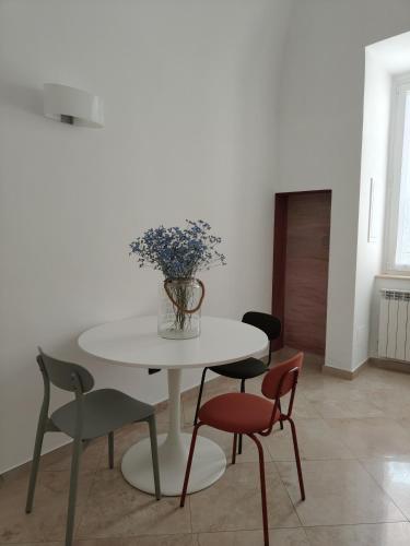 a white table with chairs and a vase of flowers on it at B&B La Botola in Bisceglie